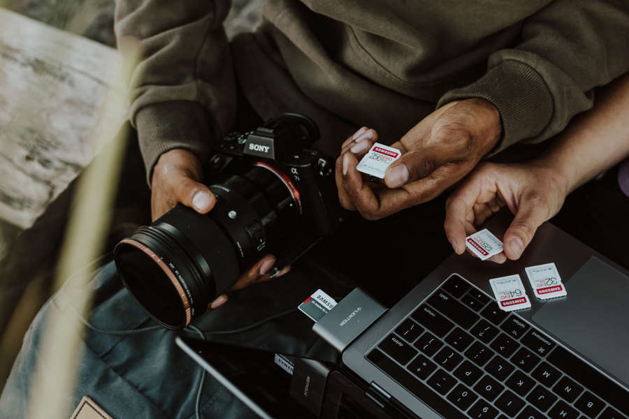 A photographer holding his camera and memory card